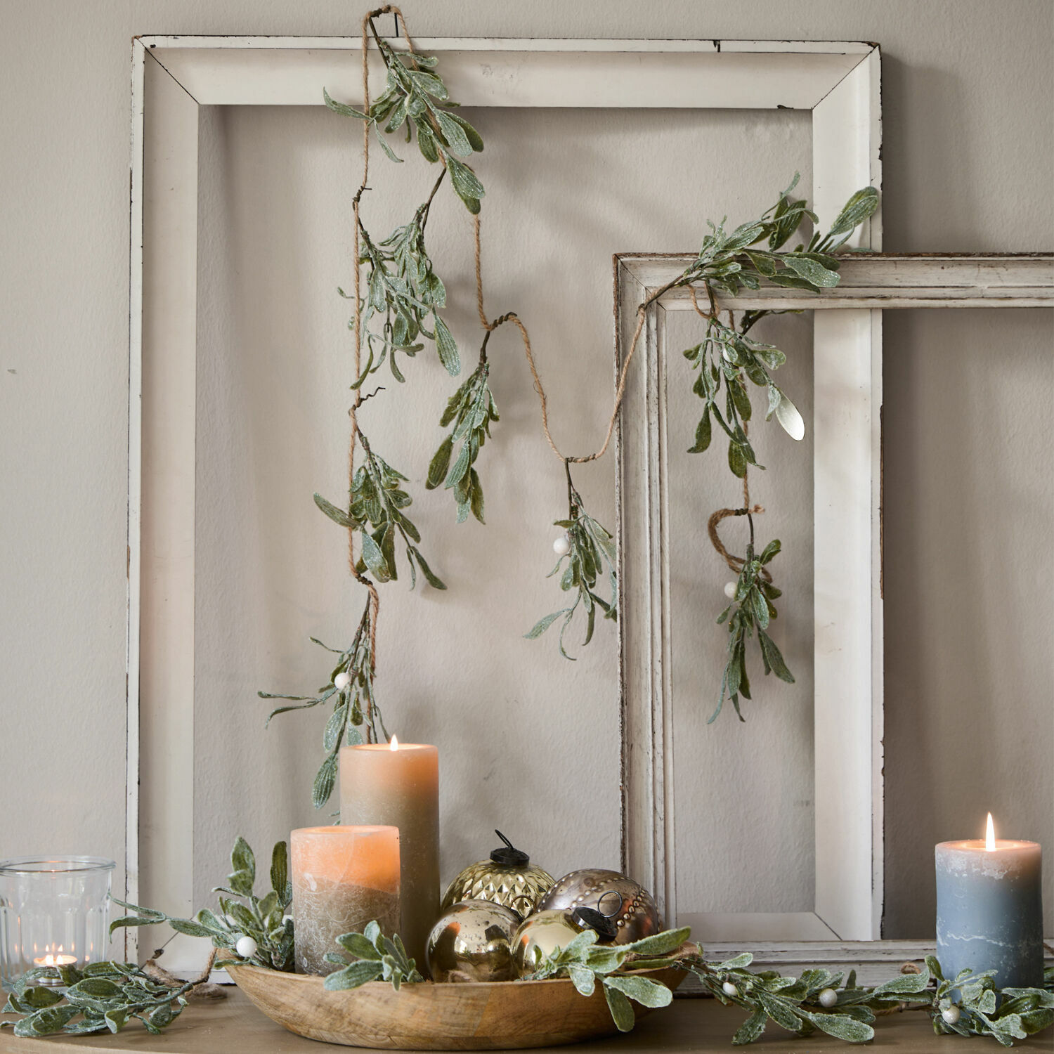 Festone Mistletoe Ghirlanda decorativa con foglie verdi e bacche bianche su cornici di legno bianche, candele e decorazioni