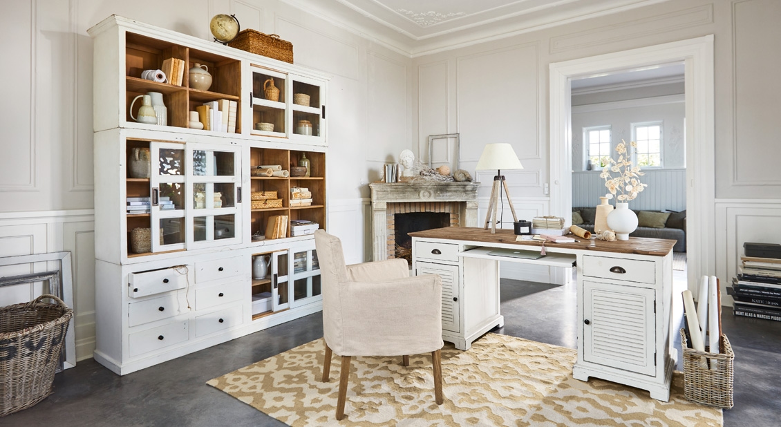 Ufficio spazioso con scrivania in legno bianco e scaffale vintage su tappeto beige in stanza luminosa
