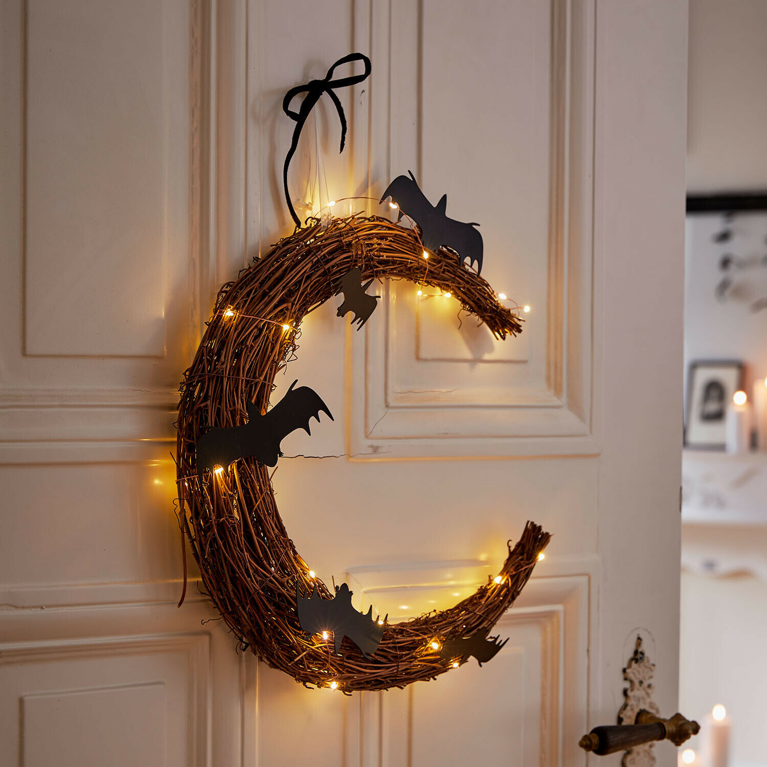 Ghirlanda a LED Brynnach Corona decorativa di rami con pipistrelli neri e luci calde appesa alla porta