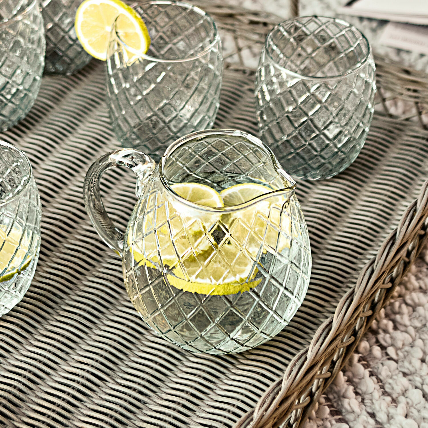 Caraffa Corrofin Caraffa e bicchieri in vetro con motivo a quadri su vassoio con fette di limone, ideali per bevande.