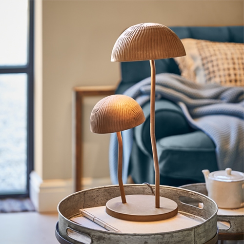 Lampada da tavolo in legno a forma di fungo colore naturale su vassoio metallico in soggiorno