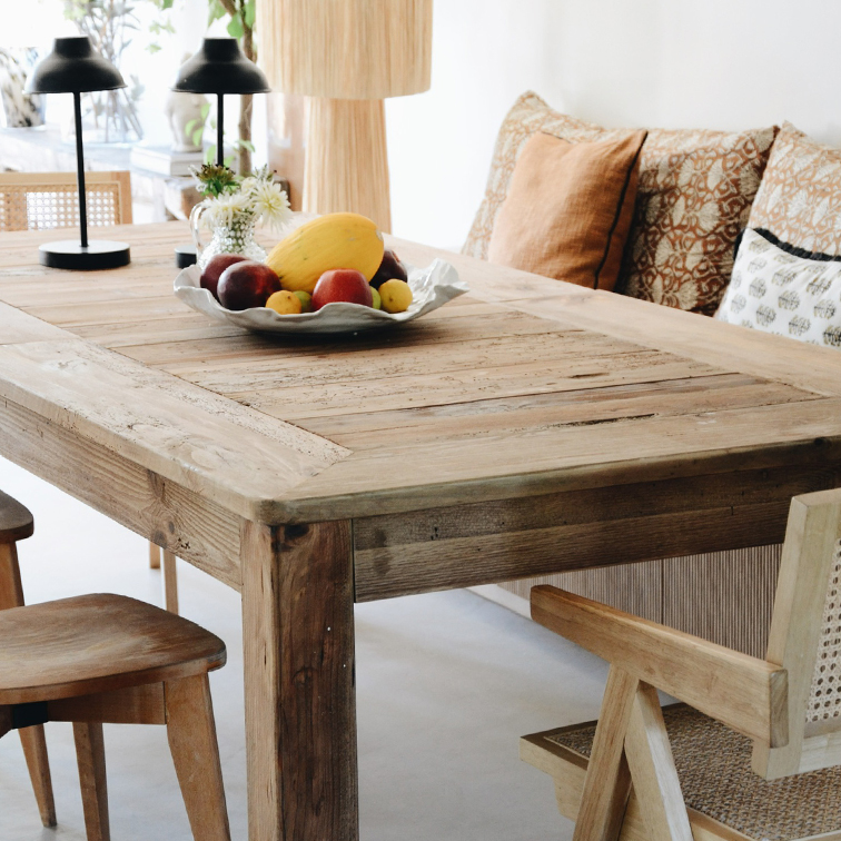 Tavolo da pranzo rustico in legno con ciotola di frutta e lampade da tavolo in ambiente luminoso
