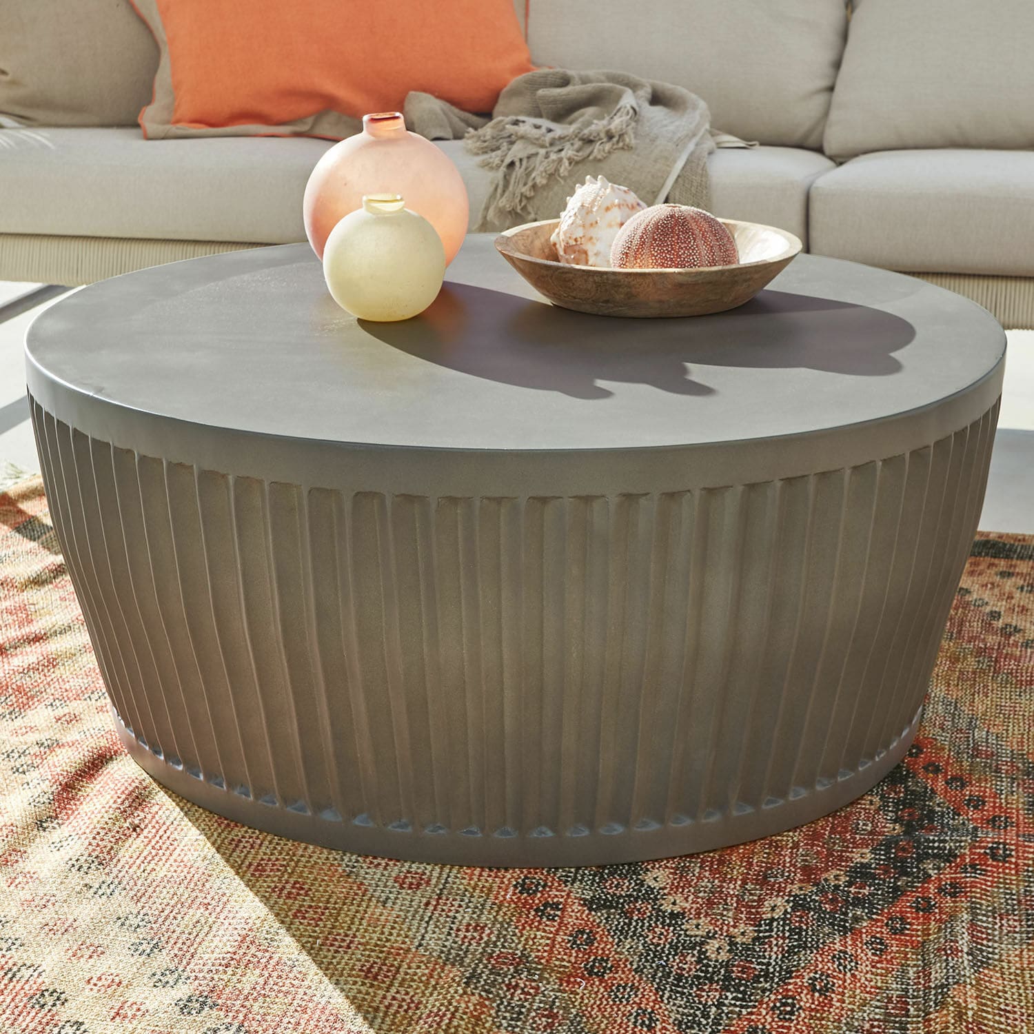 Tavolino da salotto Vesalune Tavolino rotondo in metallo grigio con base scanalata su tappeto colorato in soggiorno