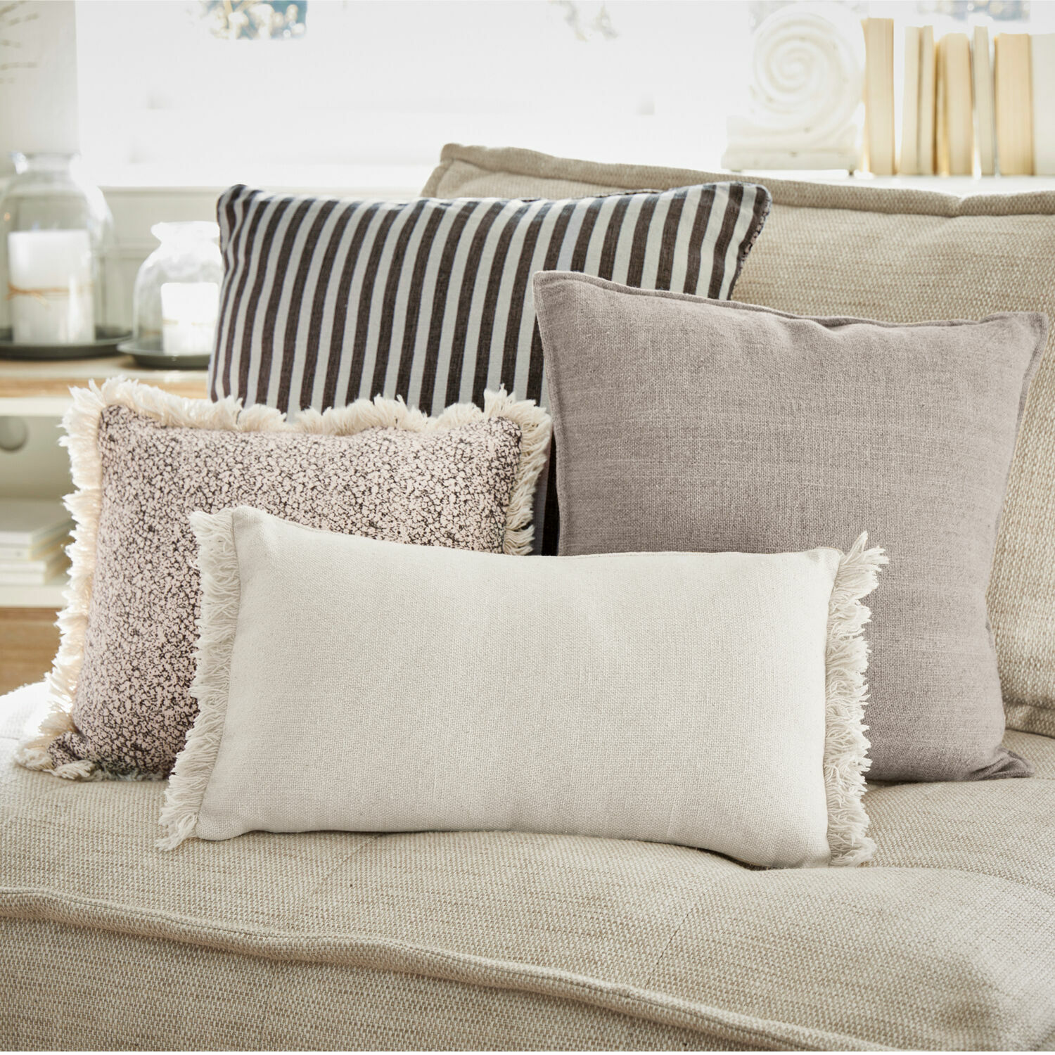 Set di 4 cuscini Valenciennes Set di quattro cuscini decorativi in tonalità neutre su un divano beige per il soggiorno