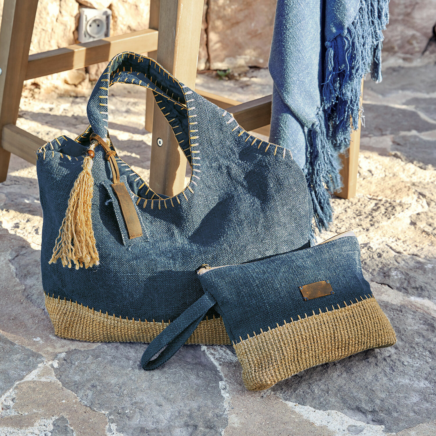 Borsa con astuccio Cacula Borsa e pochette blu scuro in materiale naturale con dettagli beige su pavimento in pietra