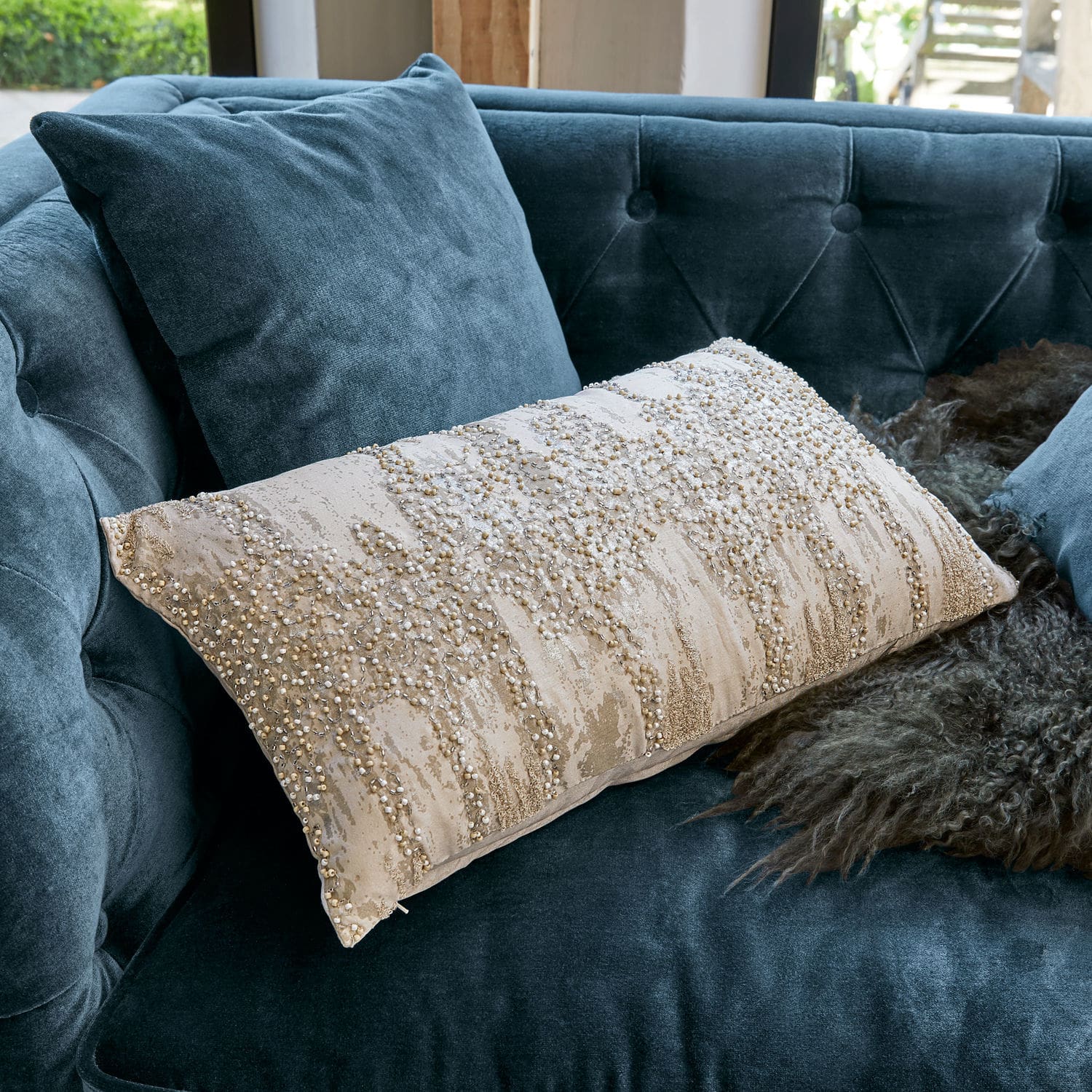 Copricuscino Aparan Cuscino decorativo beige con perline su divano in velluto blu, accessorio elegante per il soggiorno