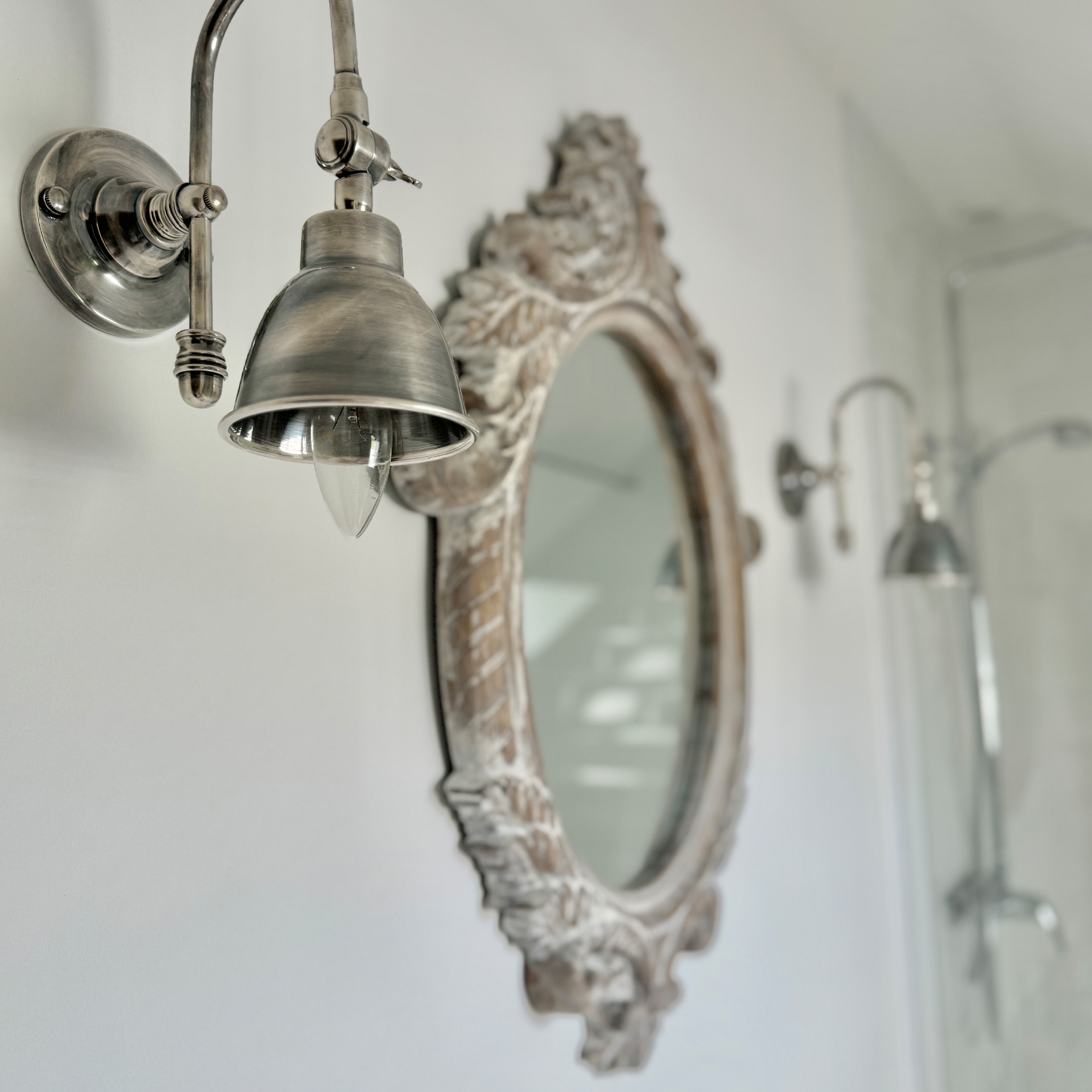 Lampada da parete in metallo vintage accanto a specchio decorativo in bagno luminoso