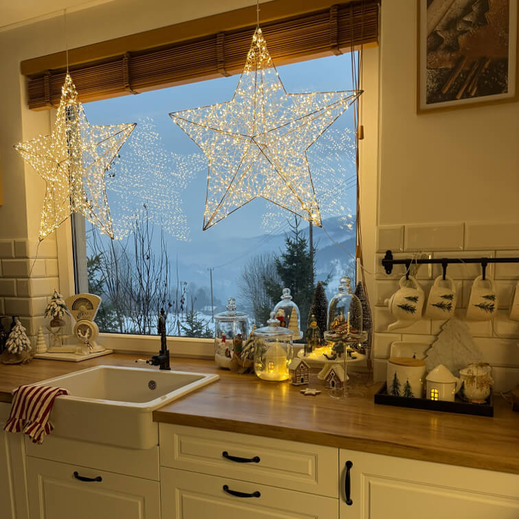 Stelle luminose decorative in cucina con piano in legno e decorazioni natalizie con vista invernale