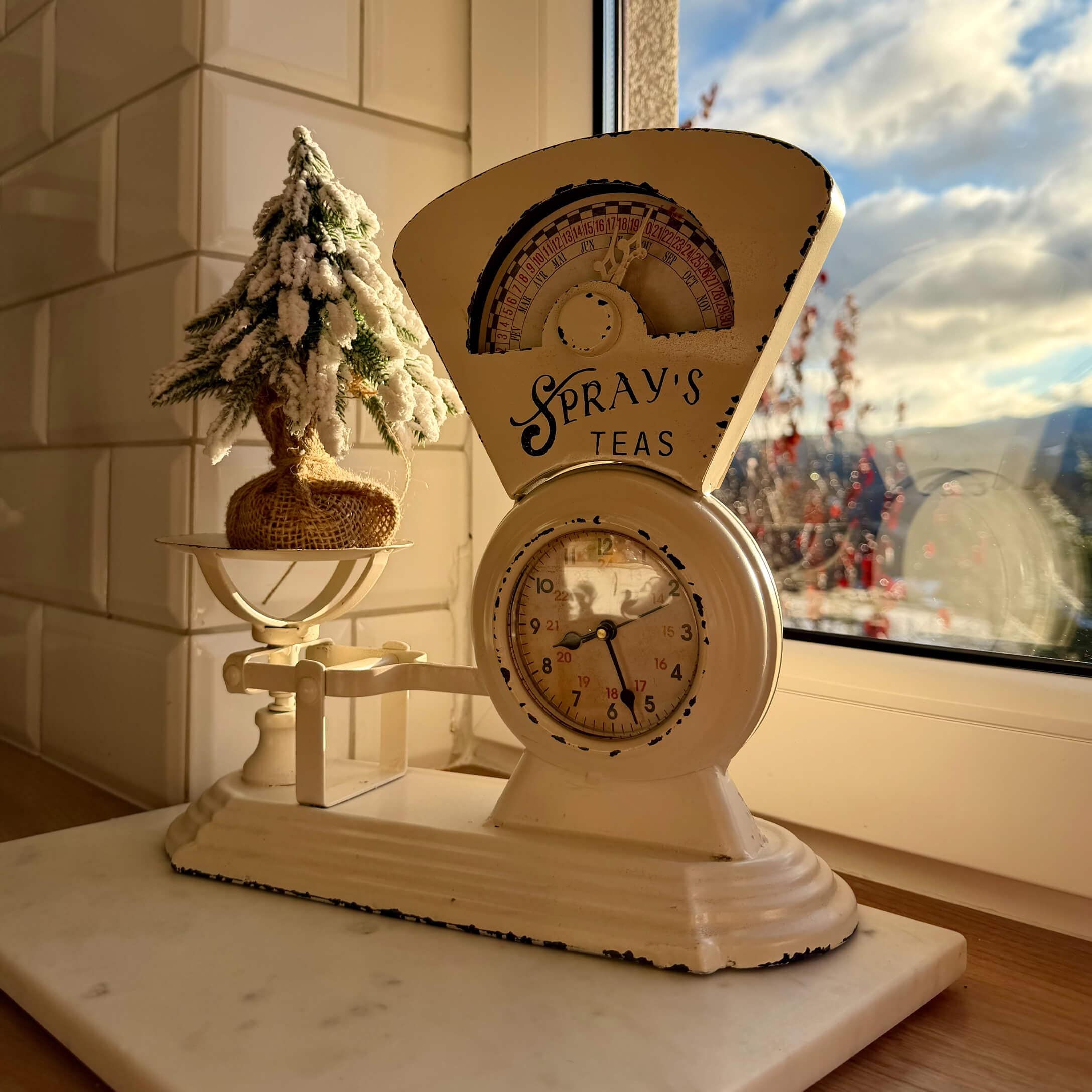 Bilancia da cucina in metallo beige con orologio e decorazione natalizia sul davanzale