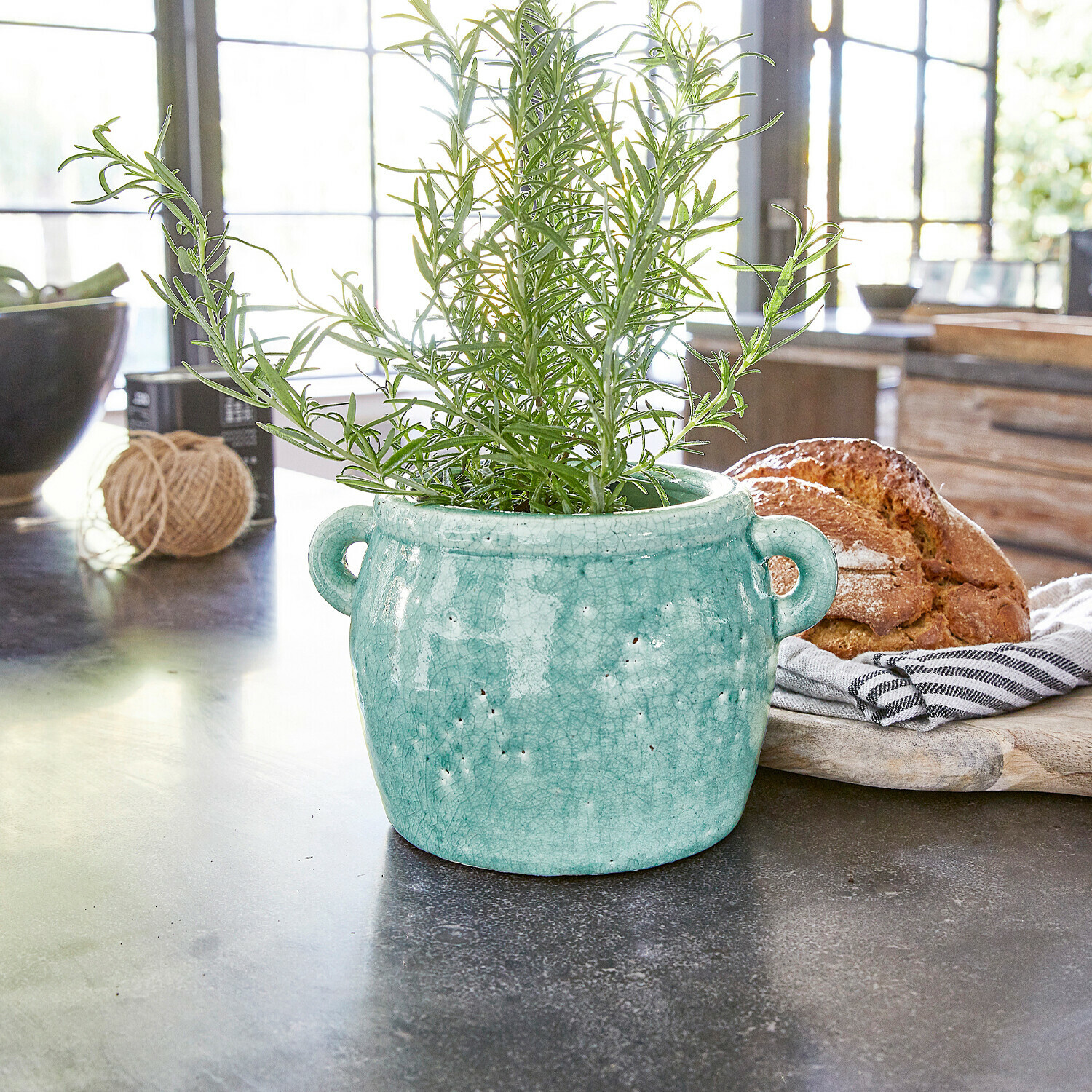 Vaso Elvin Vaso in ceramica turchese con manici e pianta verde su piano cucina con pane