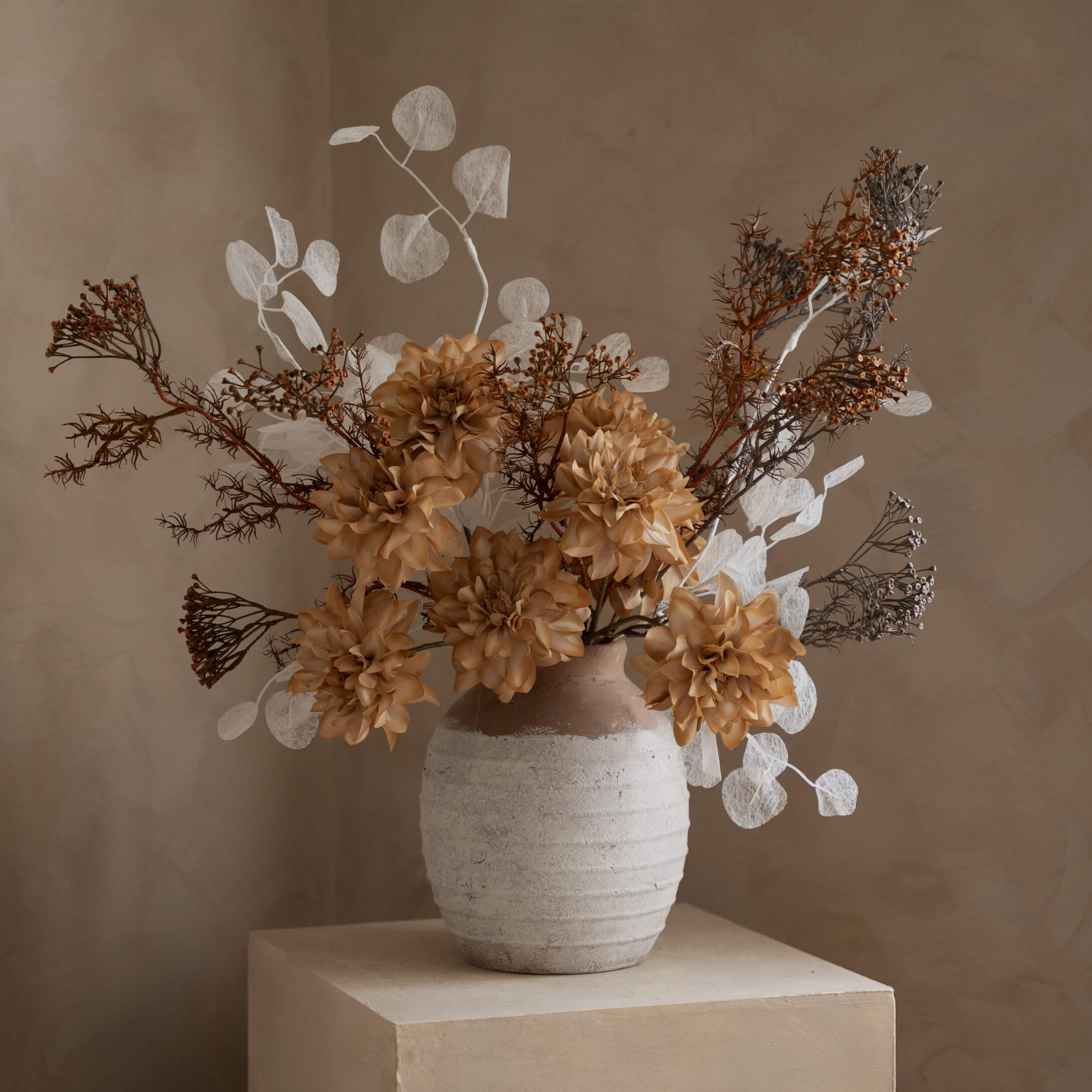 Composizione decorativa di fiori artificiali in vaso di ceramica beige e marrone per interni