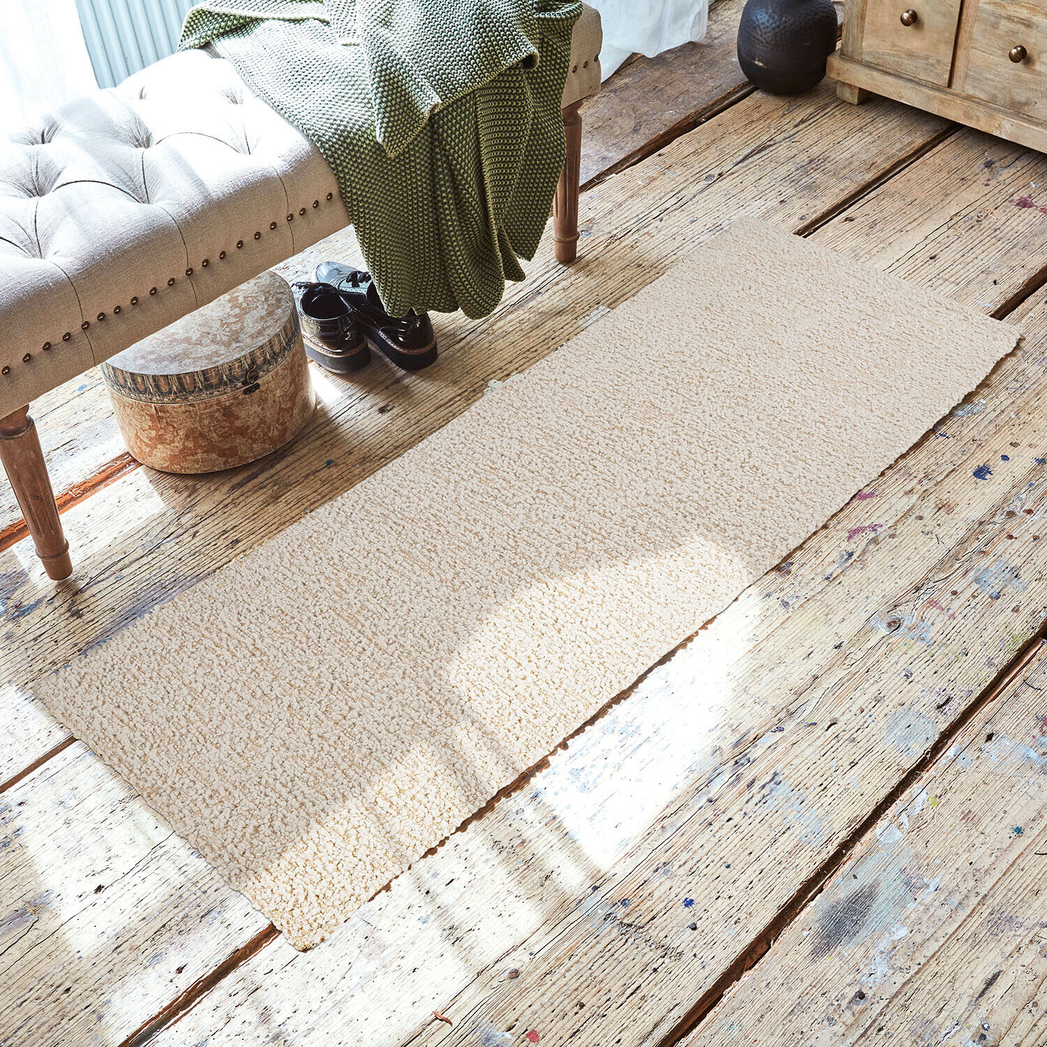 Corridore Kaleema Tappeto beige in materiale morbido su pavimento in legno in ambiente accogliente con panca e coperta verde