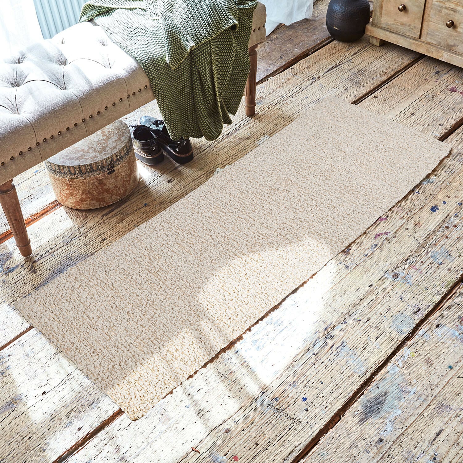 Corridore Kaleema Tappeto beige in materiale morbido su pavimento in legno in ambiente accogliente con panca e coperta verde
