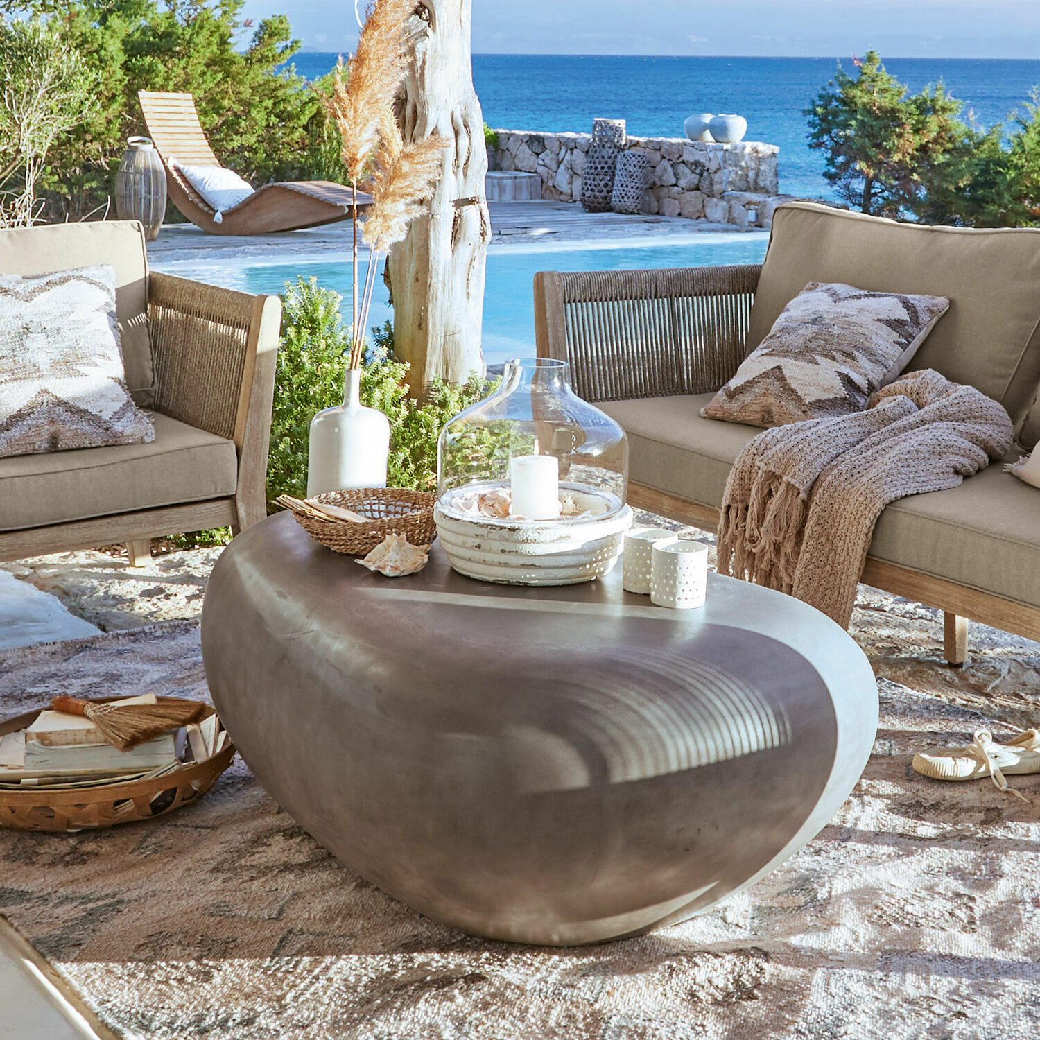 Tavolino da salotto Fermline Tavolino moderno in cemento a forma di pietra su terrazza con vista mare