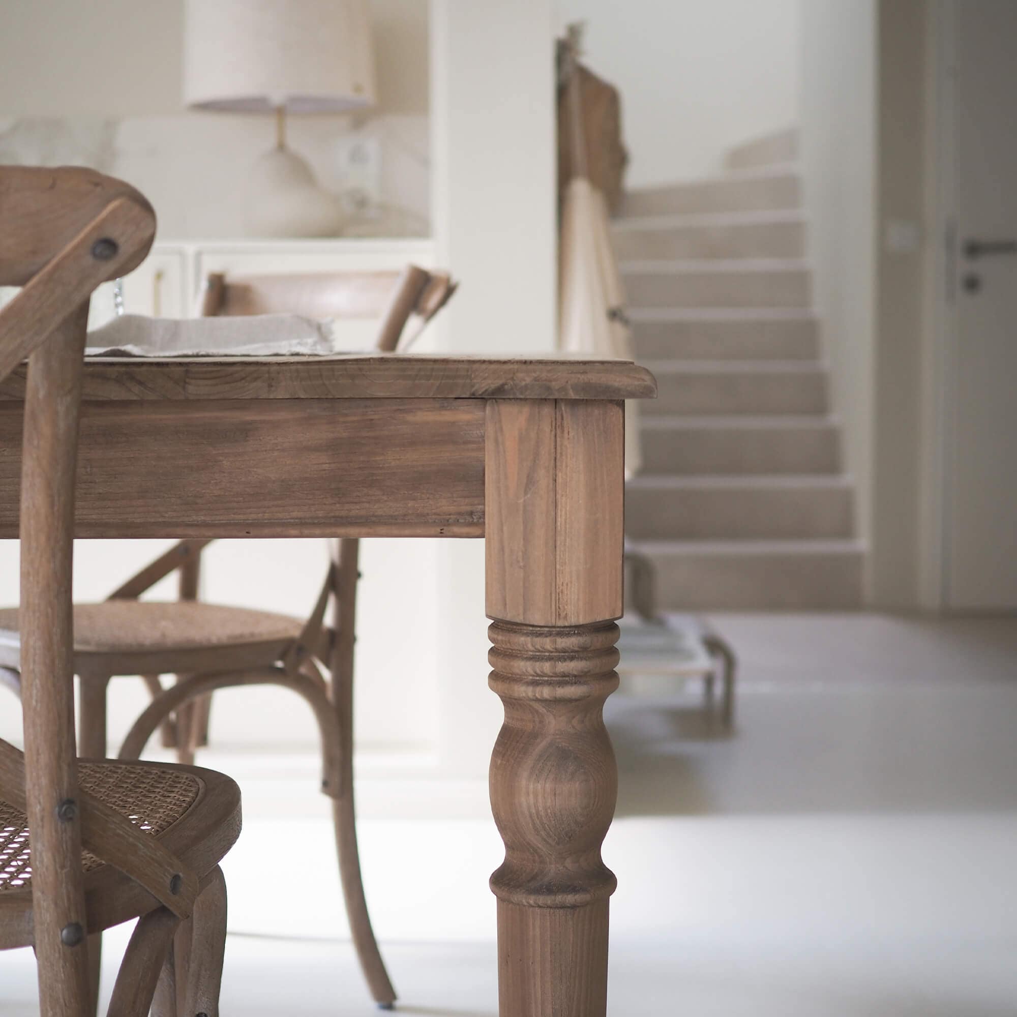 Tavolo e sedie in legno colore naturale in interno moderno luminoso con pavimento bianco