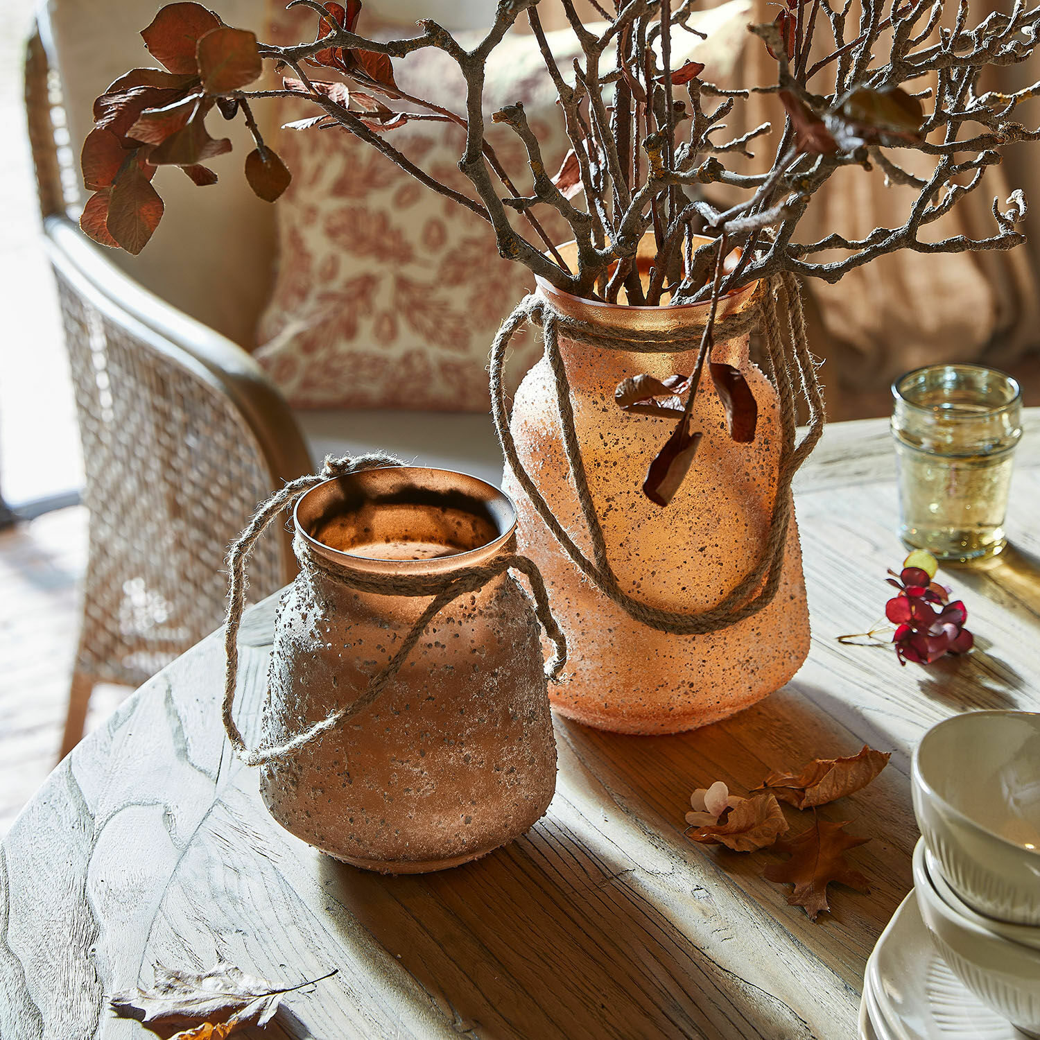 Coppia di vasi Querello Due vasi decorativi in vetro opaco arancione con corde su tavolo in legno in soggiorno luminoso