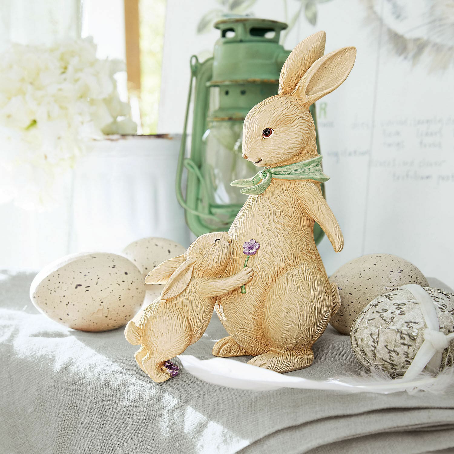 Coniglietti decorativi Susans Figure di conigli in resina beige su tavolo decorativo con uova di Pasqua