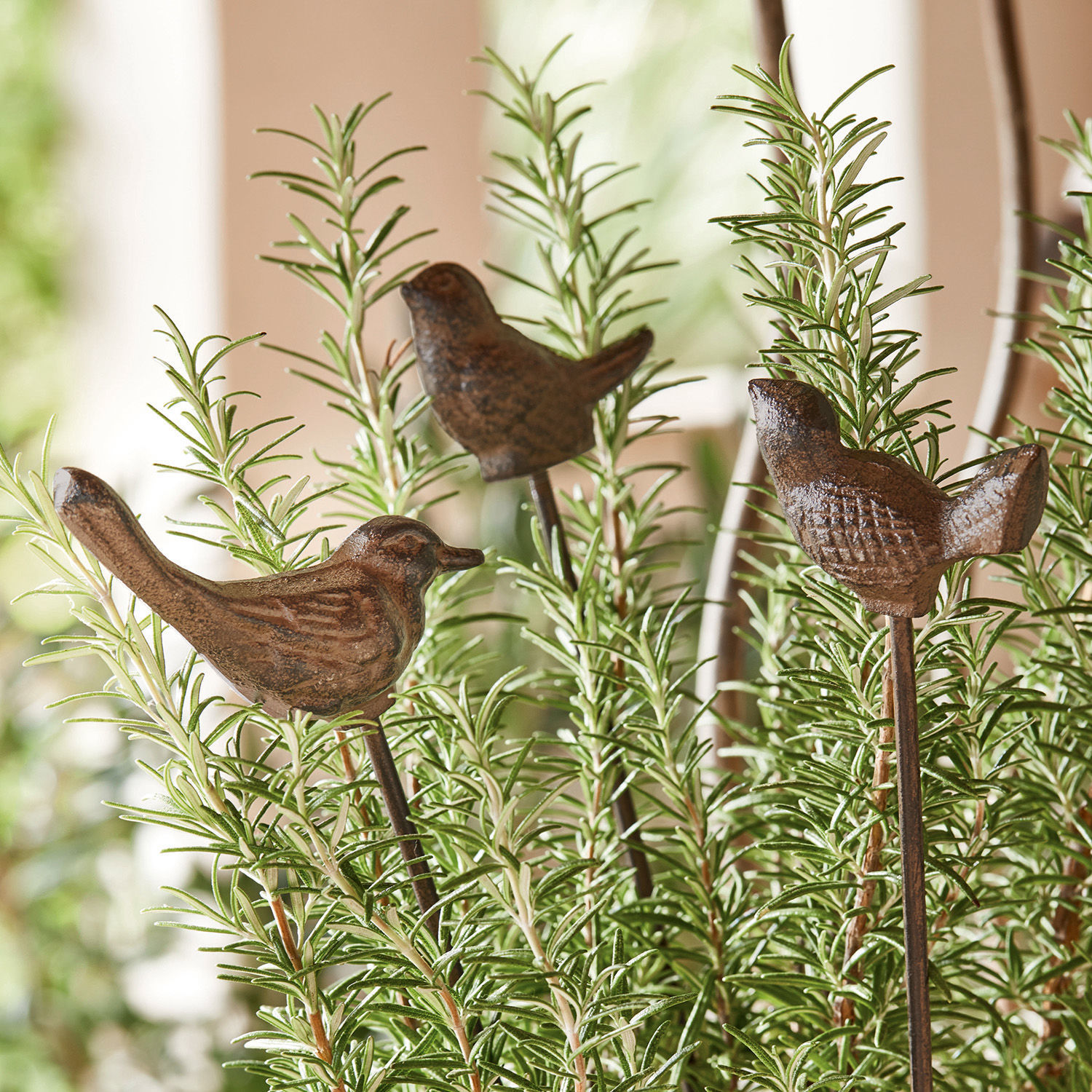 Set di 3 decorazioni da giardino con asta Laver Uccelli decorativi in metallo marrone su bastoncini tra piante verdi per giardino