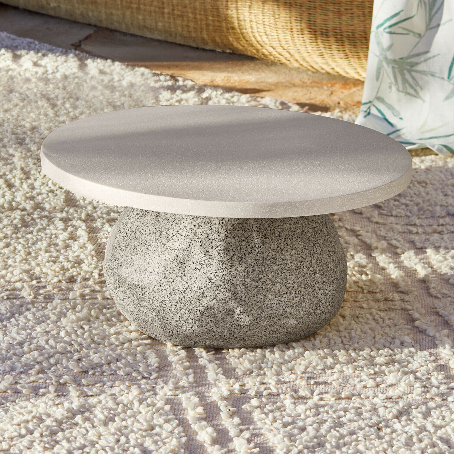 Tavolino da salotto Orivana Tavolino rotondo in pietra grigia su tappeto chiaro, design moderno e minimalista