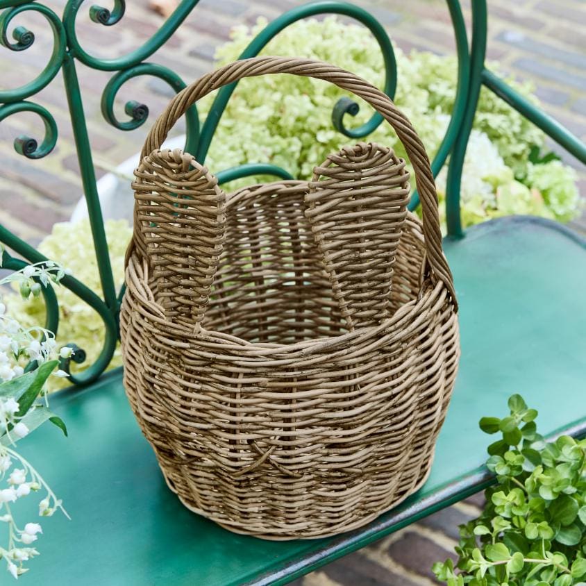 Cesto in vimini naturale con manici su panchina verde, decorazione da giardino rustica
