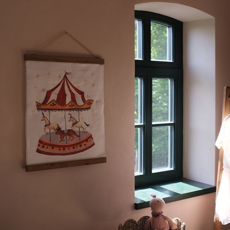 Quadro decorativo in tessuto con giostra e animali in una cameretta luminosa