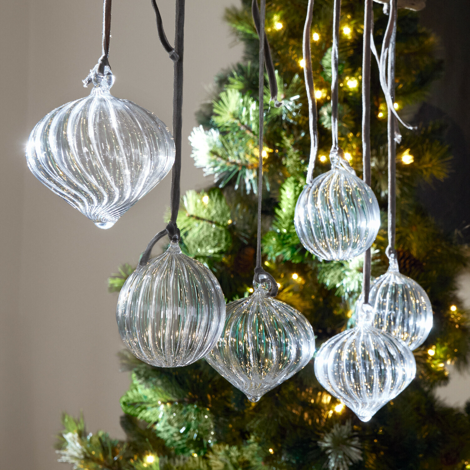 Set di 6 palline di Natale Bavella Palline di Natale in vetro trasparente con scanalature appese davanti a un albero illuminato