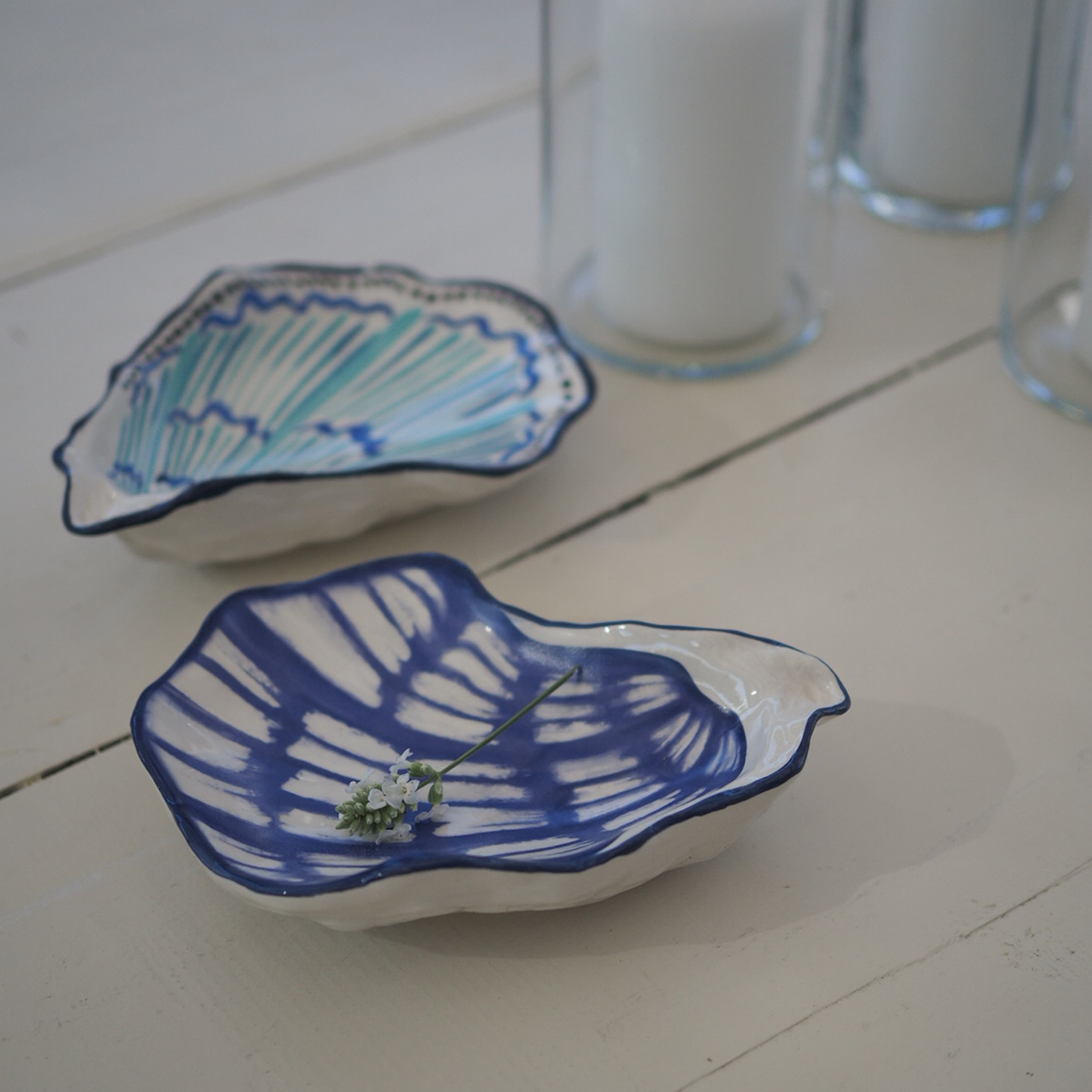 Piccole ciotole in ceramica a forma di conchiglia con motivo blu e turchese su sfondo bianco, decorazione da tavola