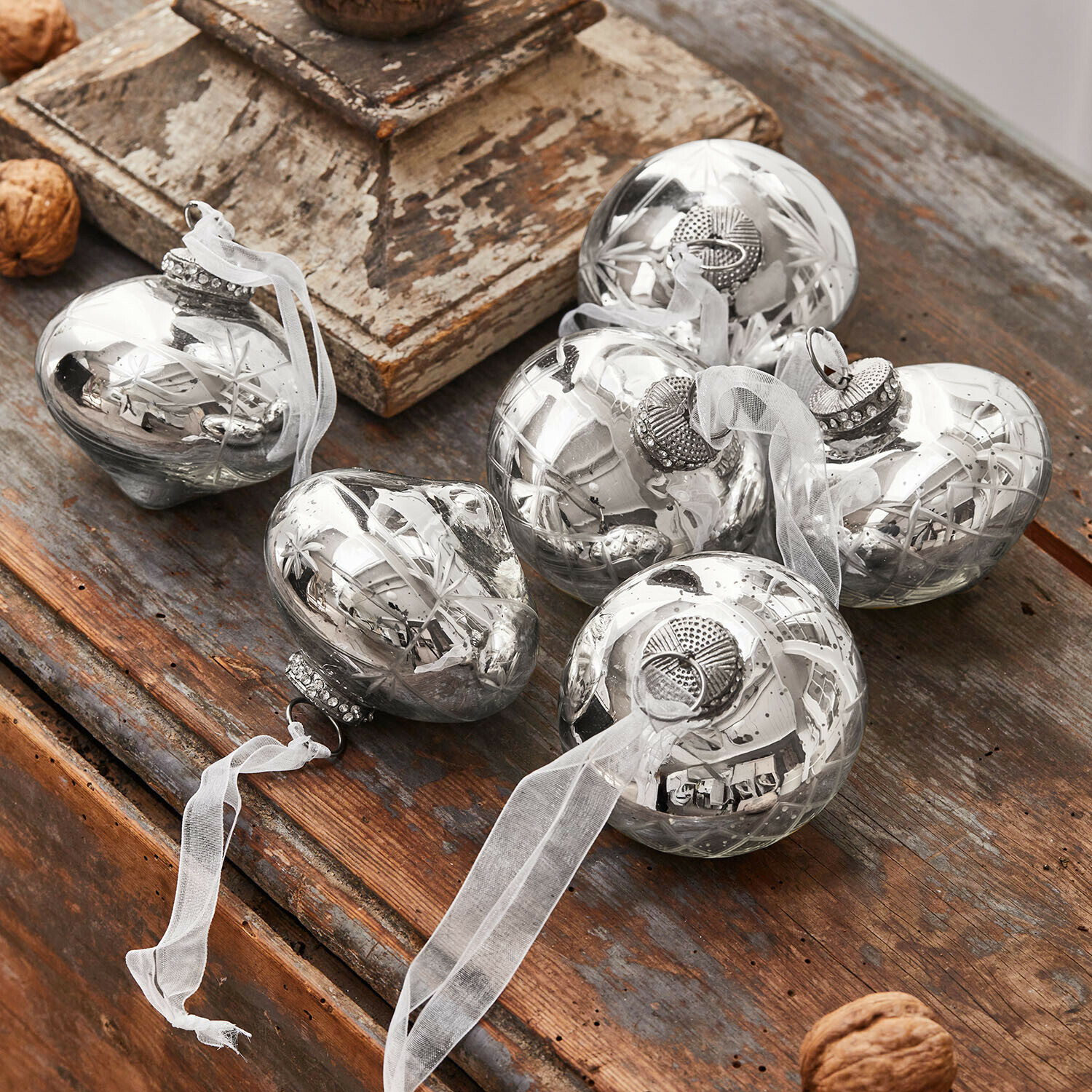 Set di 6 decorazioni natalizie Cheshire Palline di Natale in vetro argentato con nastro bianco su tavolo in legno, decorazioni festive