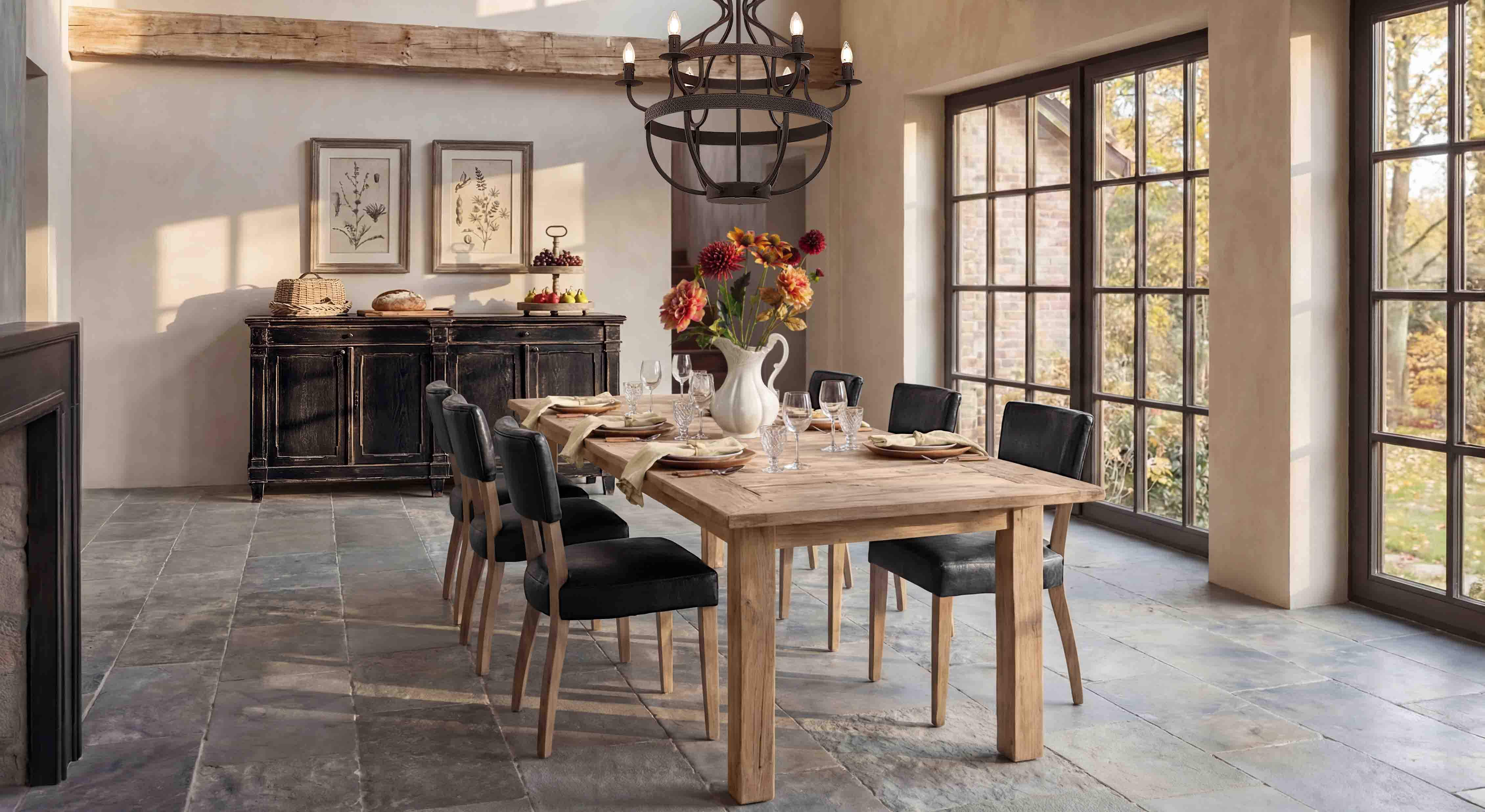 Sala da pranzo con tavolo in legno chiaro e sedie nere, luce naturale da grandi finestre
