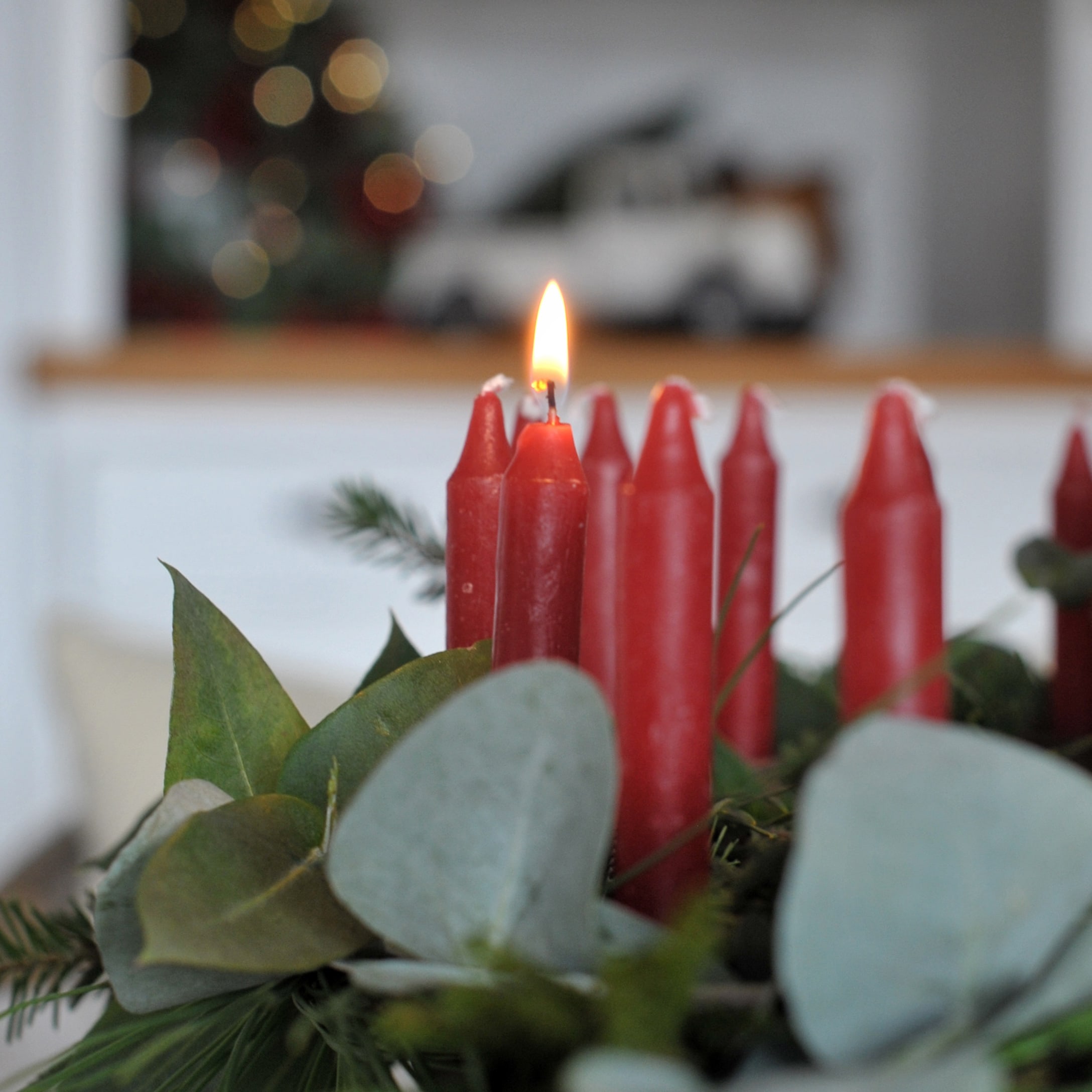 Candele rosse dell'Avvento con foglie verdi per decorazione natalizia festiva