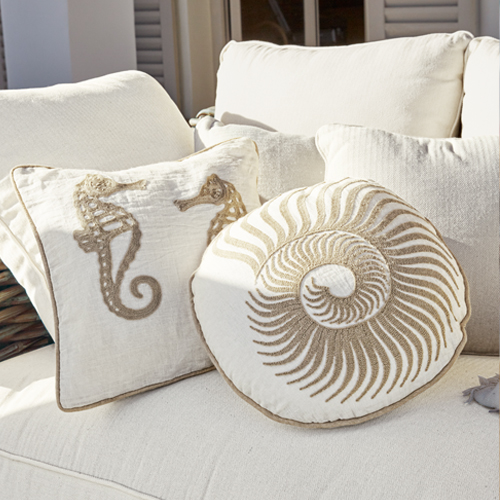 Cuscini decorativi con motivi marini su tessuto crema su divano, stile marinaro