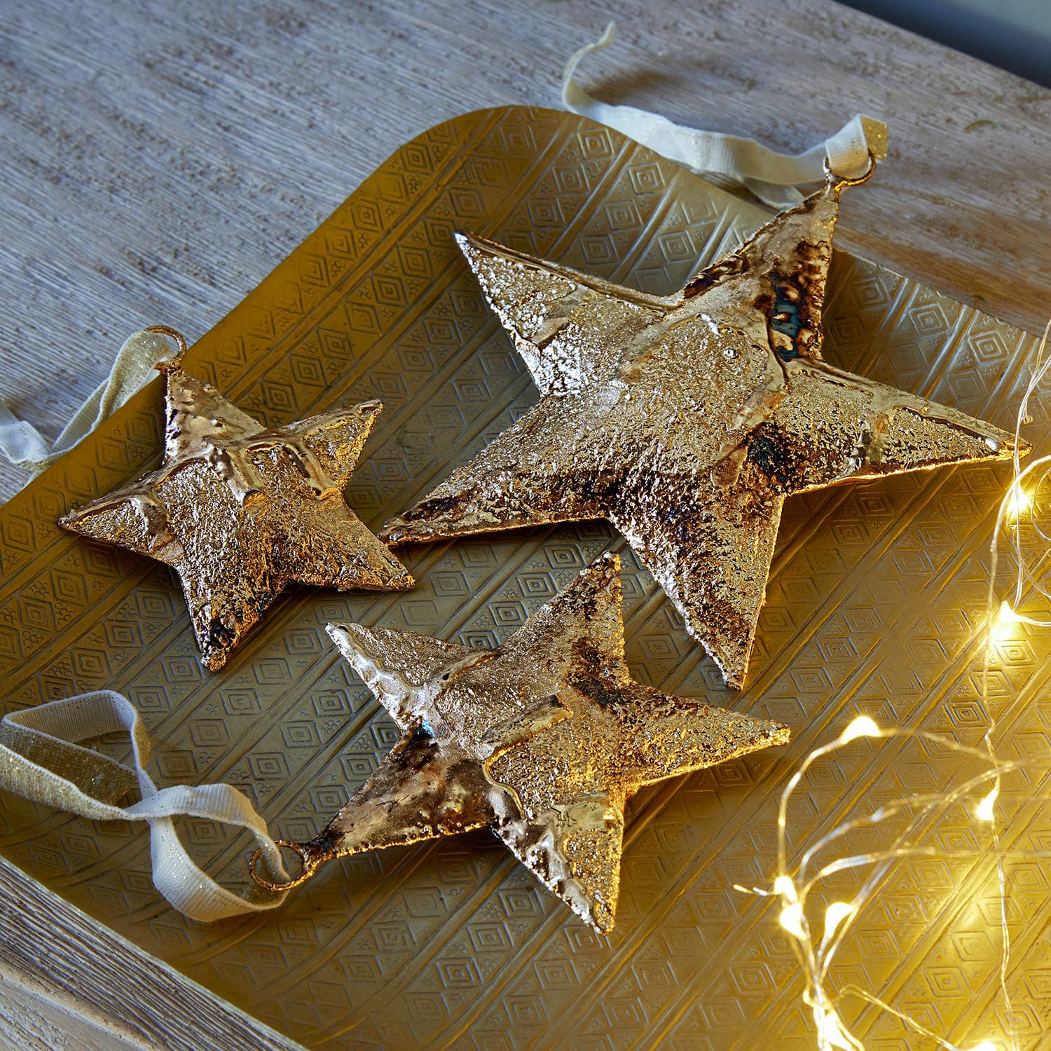 Set di 3 ciondoli Myrska Set di tre stelle decorative in metallo dorato su vassoio dorato con luci LED