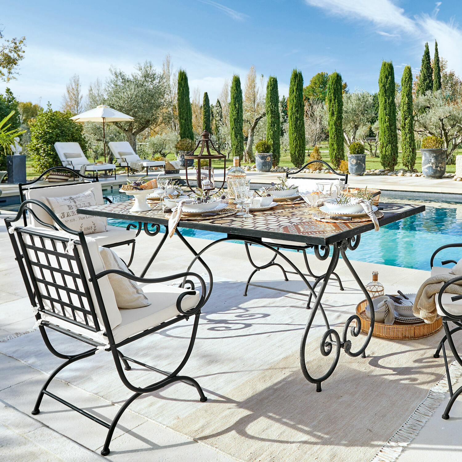 Tavolo Grainville Set di mobili da giardino in metallo con tavolo a mosaico vicino alla piscina in una giornata di sole