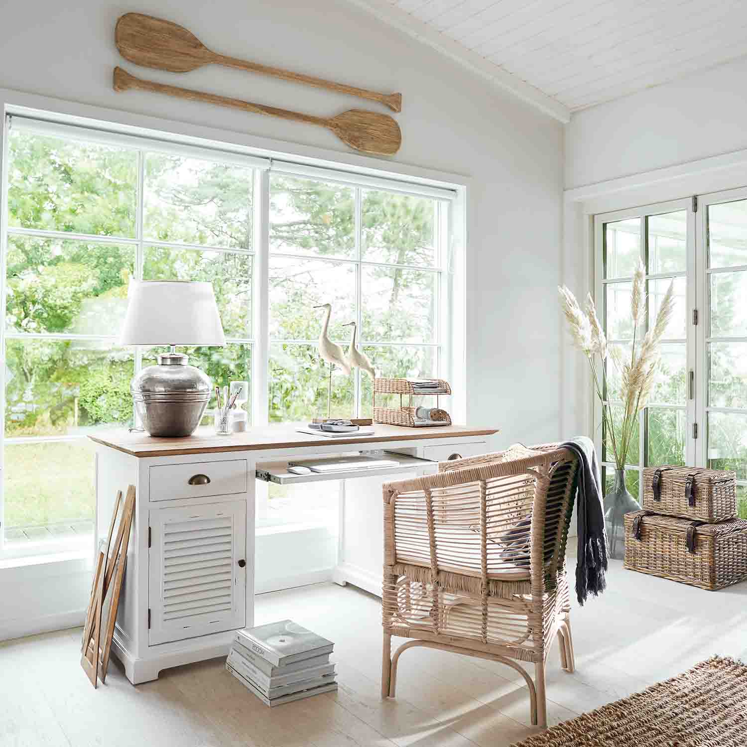 Ufficio luminoso con scrivania in legno bianco e sedia in rattan in stile naturale e accogliente