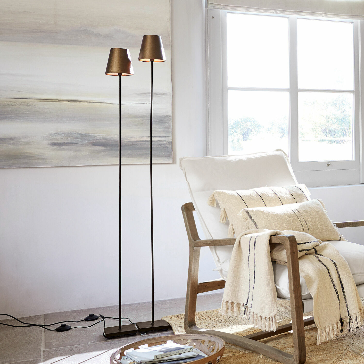 Coppia di lampade a stelo Tacoma Due lampade da terra sottili con paralumi in metallo dorato in un soggiorno luminoso e moderno