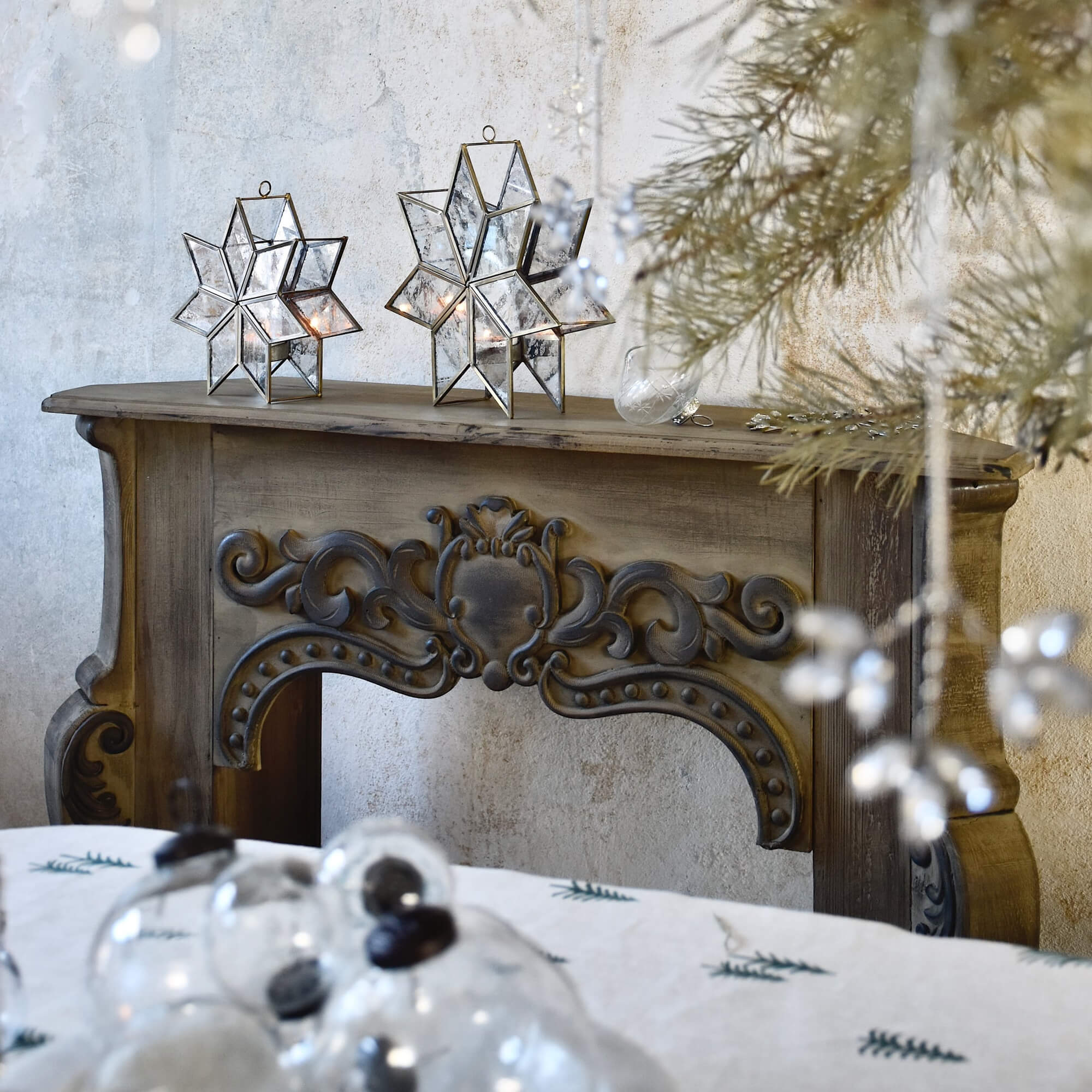 Consolle camino in legno con intagli vintage e decorazioni dettagliate su sfondo muro neutro