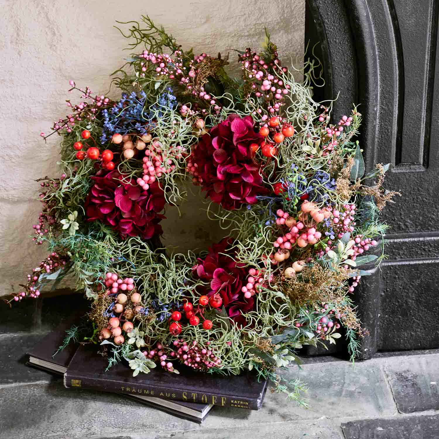 Corona decorativa con fiori rossi e bacche colorate per porta, decorazione stagionale