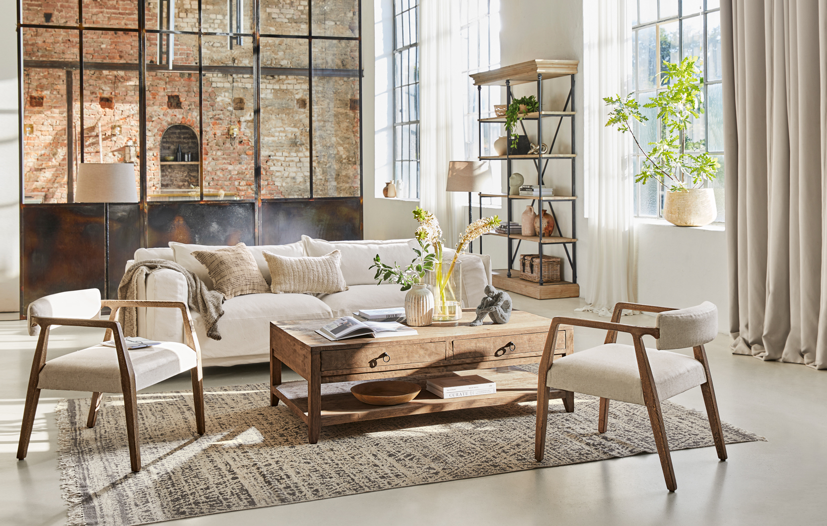 Soggiorno in stile loft con tavolino in legno e divano crema su tappeto decorativo