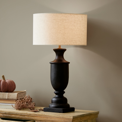 Lampada da tavolo in ceramica nera con paralume beige su tavolo in legno, decorazione d'interni