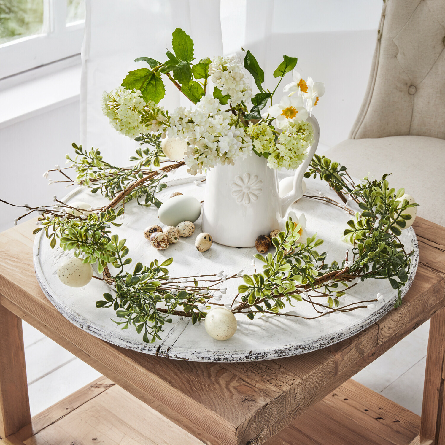 Festone Antonin Corona decorativa con foglie verdi e uova su vassoio in legno bianco con brocca in ceramica e fiori
