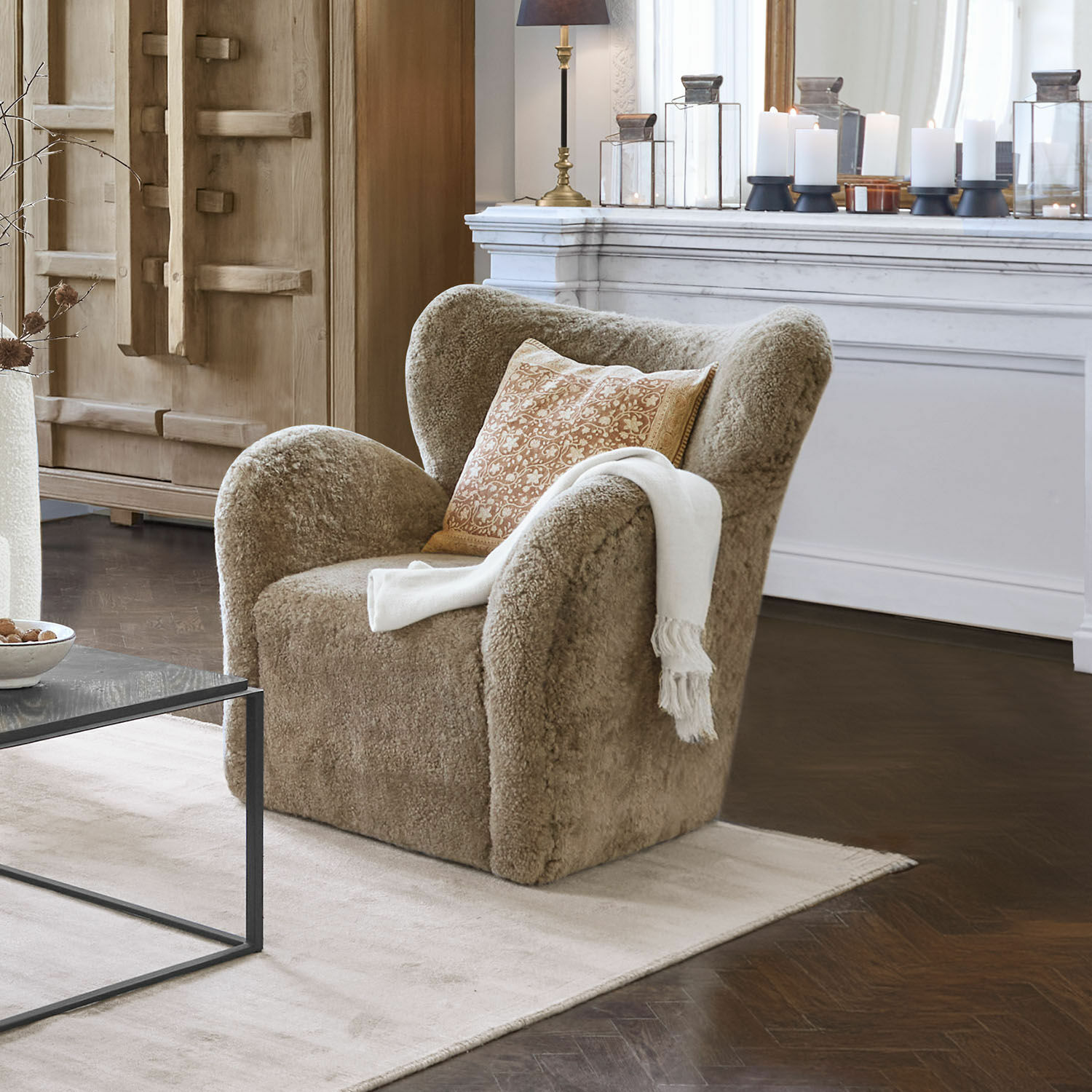 Poltrona Ambrécourt Poltrona beige in materiale morbido con cuscino e coperta bianca in soggiorno elegante