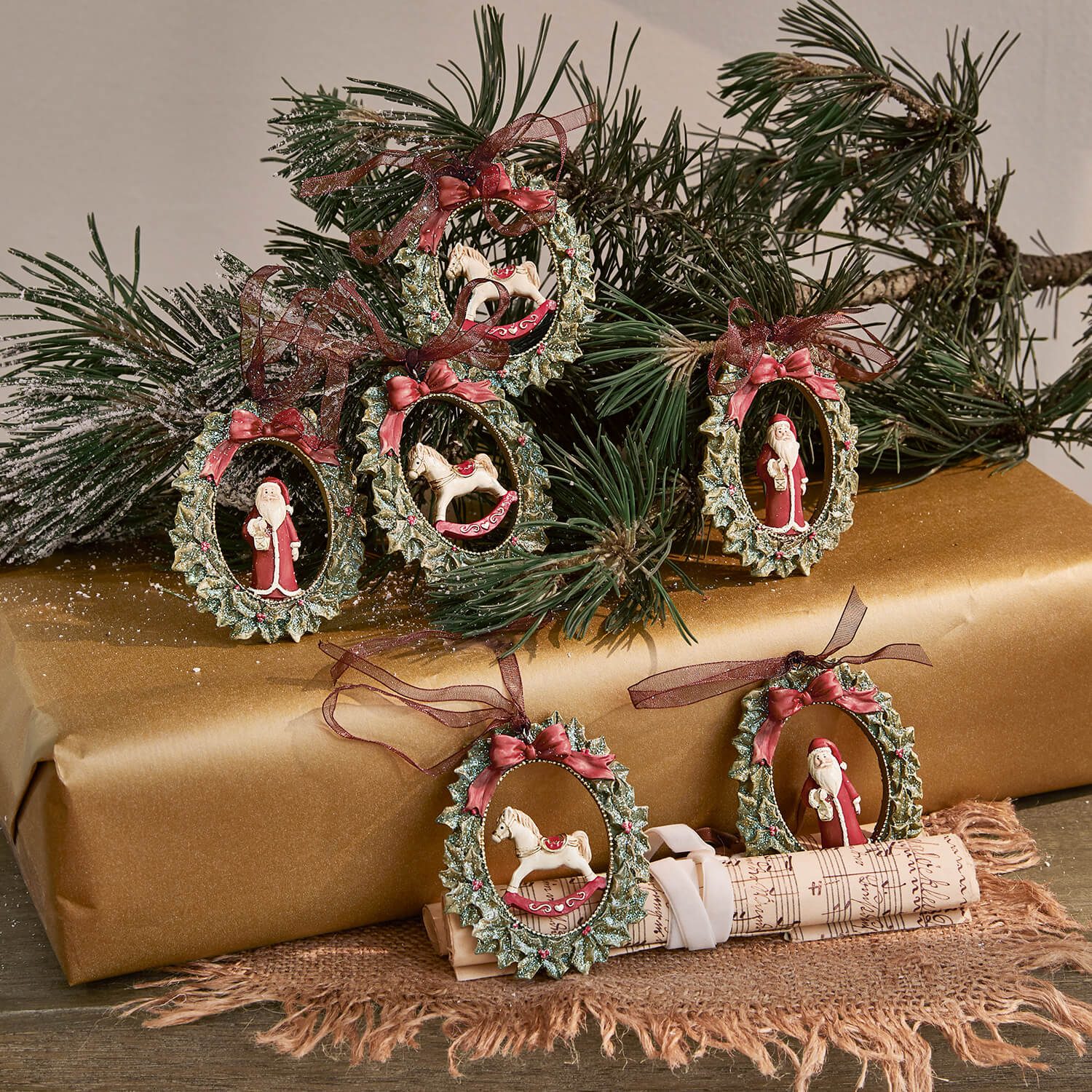 Set di decorazioni natalizie con corone verdi, fiocchi rossi e figure di Babbo Natale e cavallo a dondolo