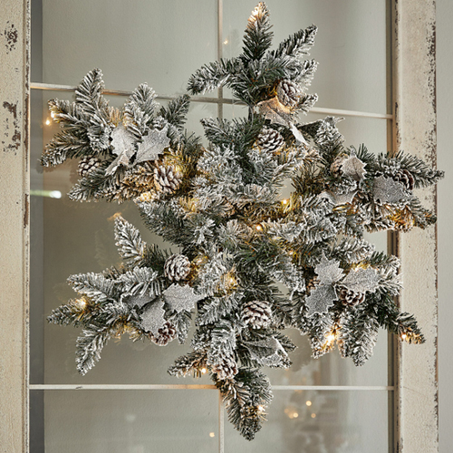Decorazione natalizia con rami di pino innevati, pigne e luci LED integrate per l'arredo