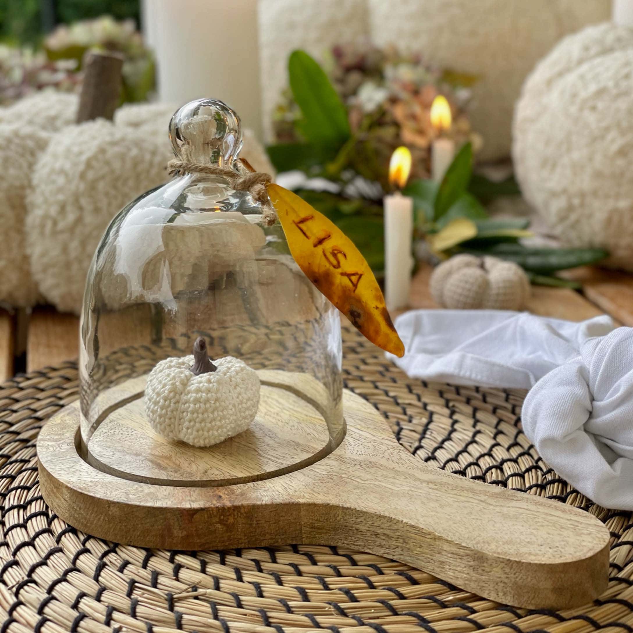 Campana di vetro su base in legno con zucca bianca all'uncinetto per decorazione autunnale