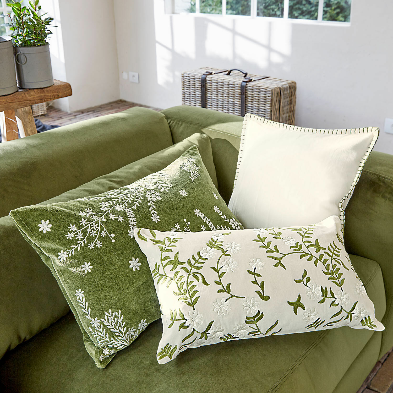 Set di 3 copricuscini Iplique Set di tre cuscini decorativi ricamati in tonalità verdi e crema su divano verde