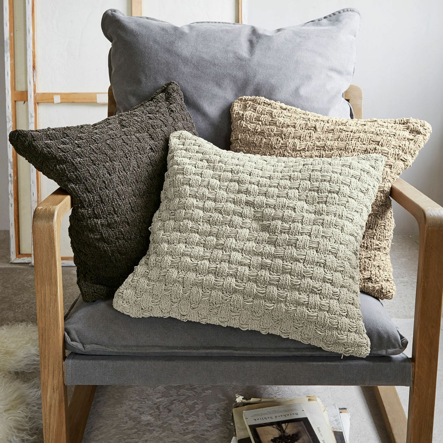 Set di 3 copricuscini Antier Set di tre cuscini decorativi in tessuto intrecciato beige e marrone su poltrona grigia