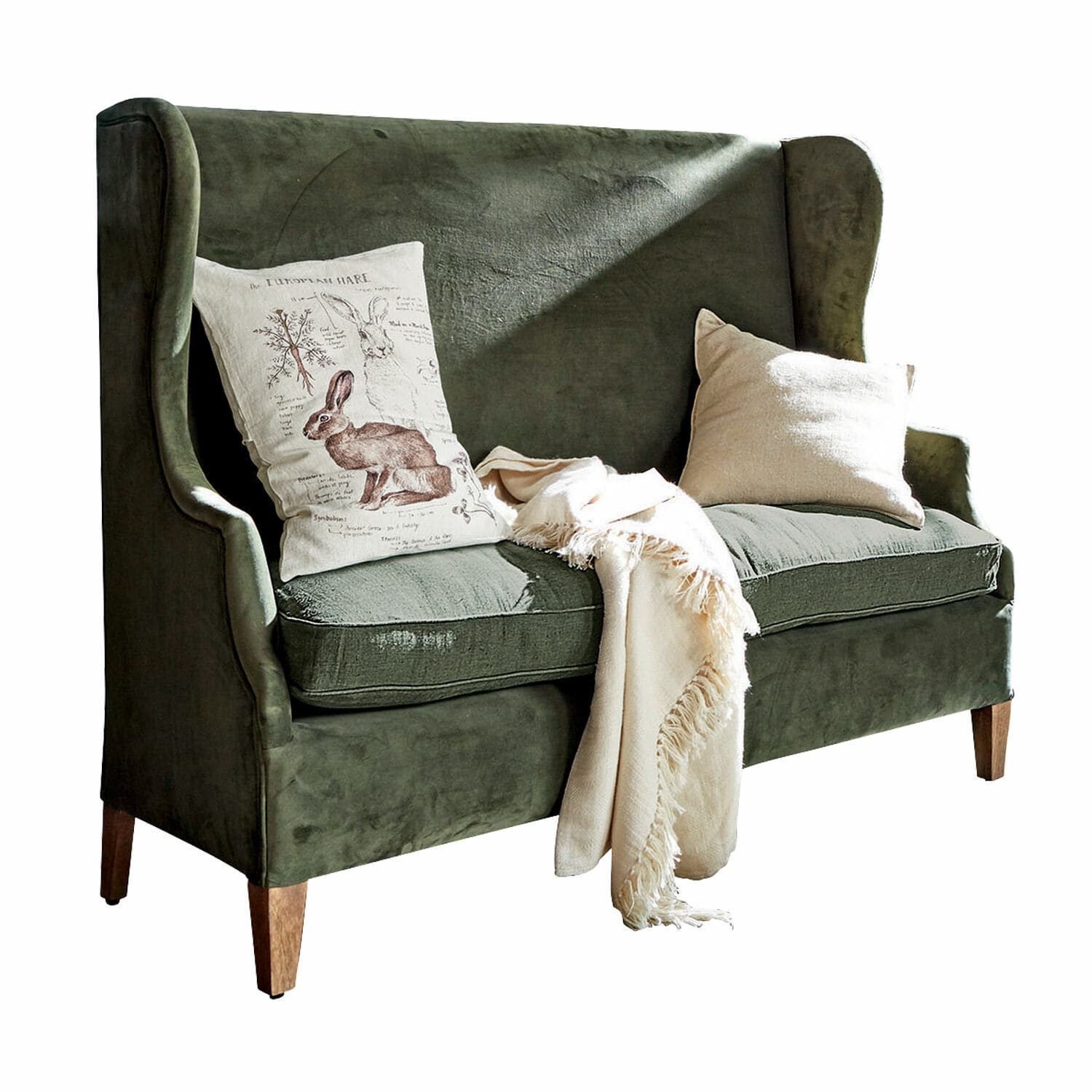 Divano Ombra Divano verde in velluto con gambe in legno, cuscini decorativi e coperta crema