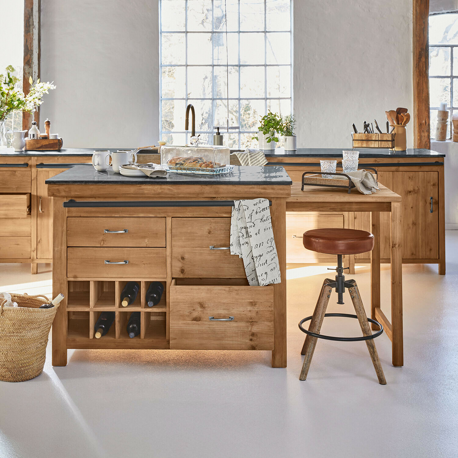 Mobile da cucina Sunnybrook Cucina con isola in legno naturale e sgabello con seduta in pelle marrone, piano in pietra scura