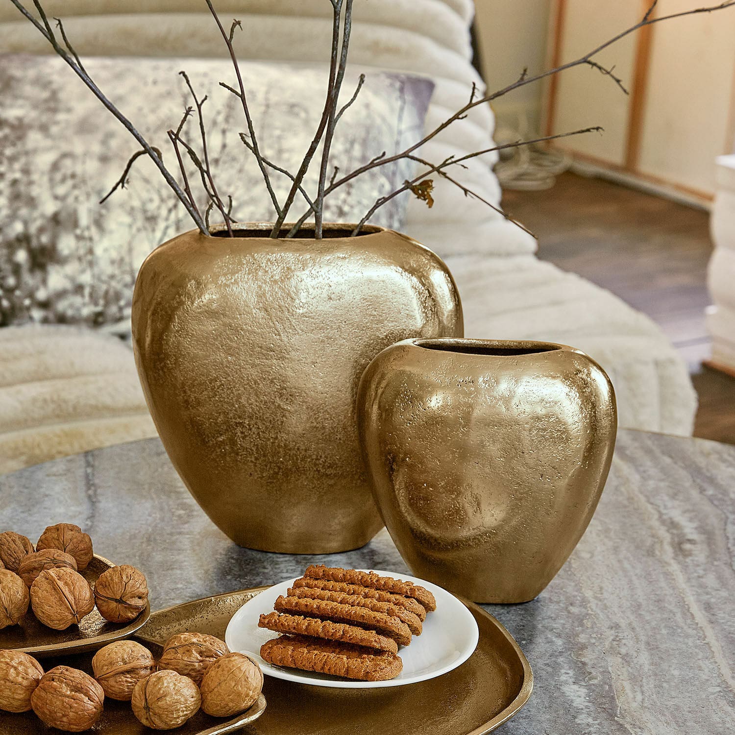 Coppia di vasi Cezelle Set di due vasi in ceramica dorata su tavolo con noci e biscotti in soggiorno