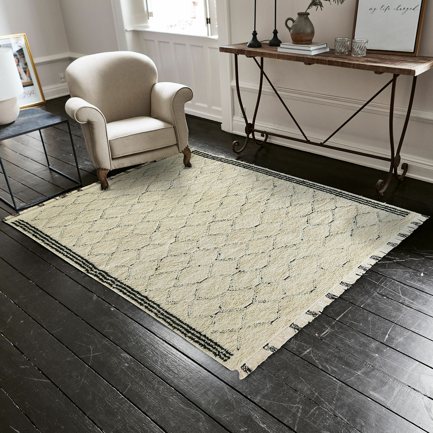 Tappeto Himesto Tappeto beige con motivo geometrico e frange su pavimento in legno scuro in soggiorno